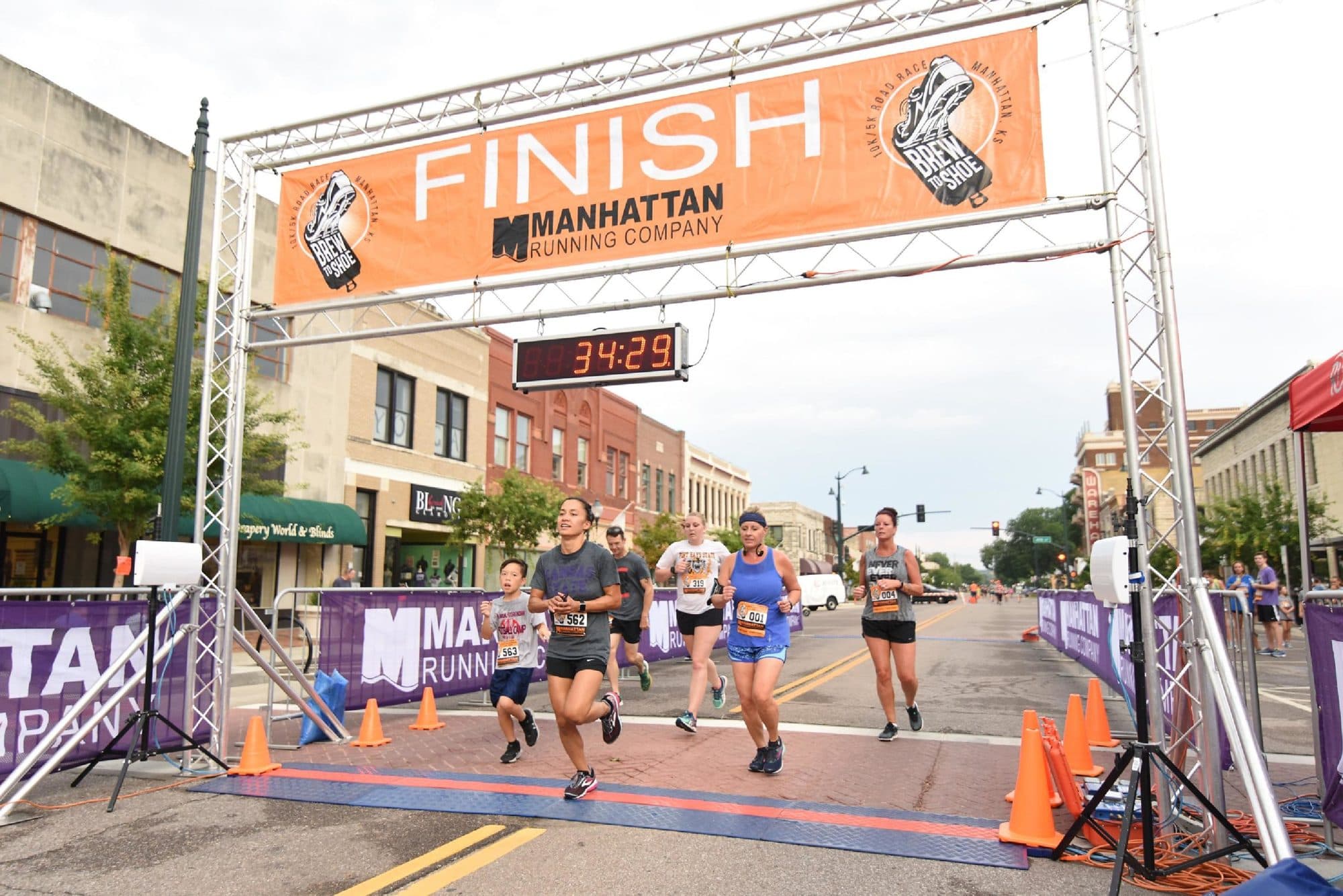 Runners coming into a finish clock at a race timed by Red Dirt